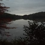 Lake at dusk, with cloudy sky and dark hills