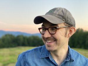 Headshot of Barry Matthews, with field, trees, and hills in background