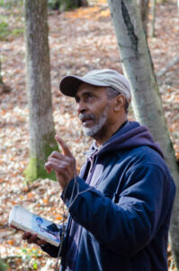 John Green pointing in the woods while teaching.